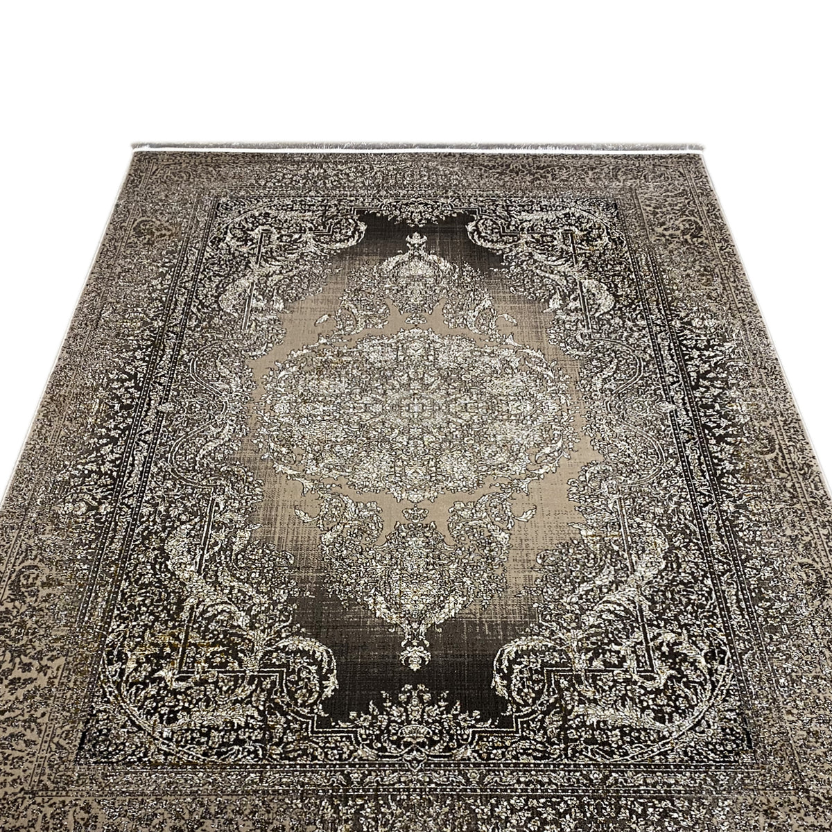Alfombra vista de frente con un gran medallón ornamental, fondo oscuro y remate de flecos