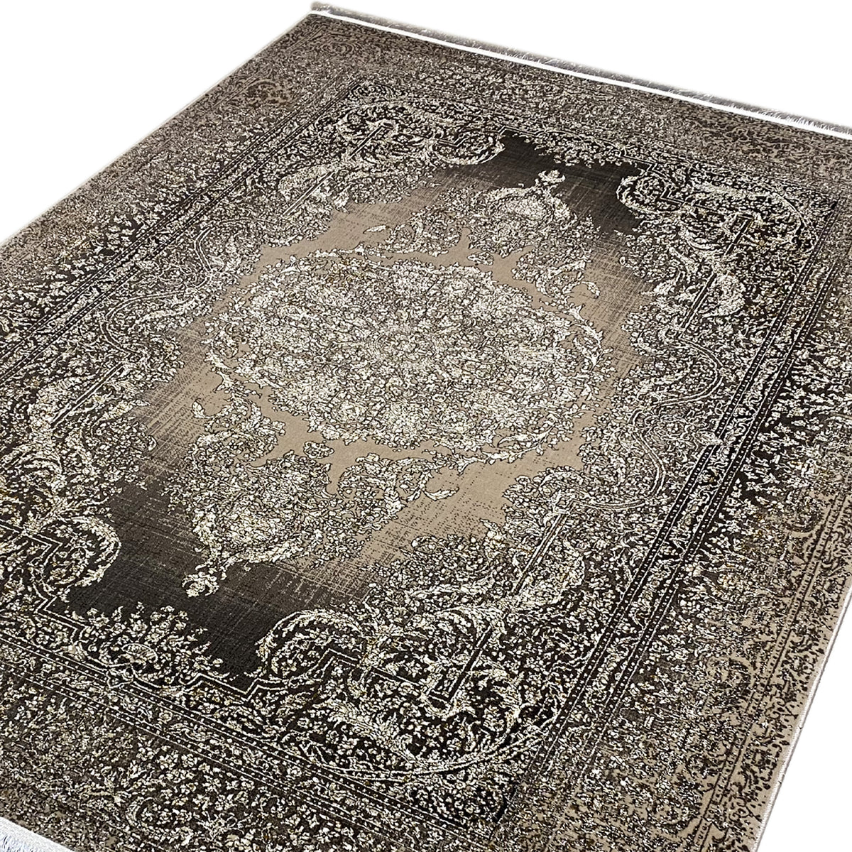 Alfombra en primer plano con el motivo central, de color marrón grisáceo con detalles beige