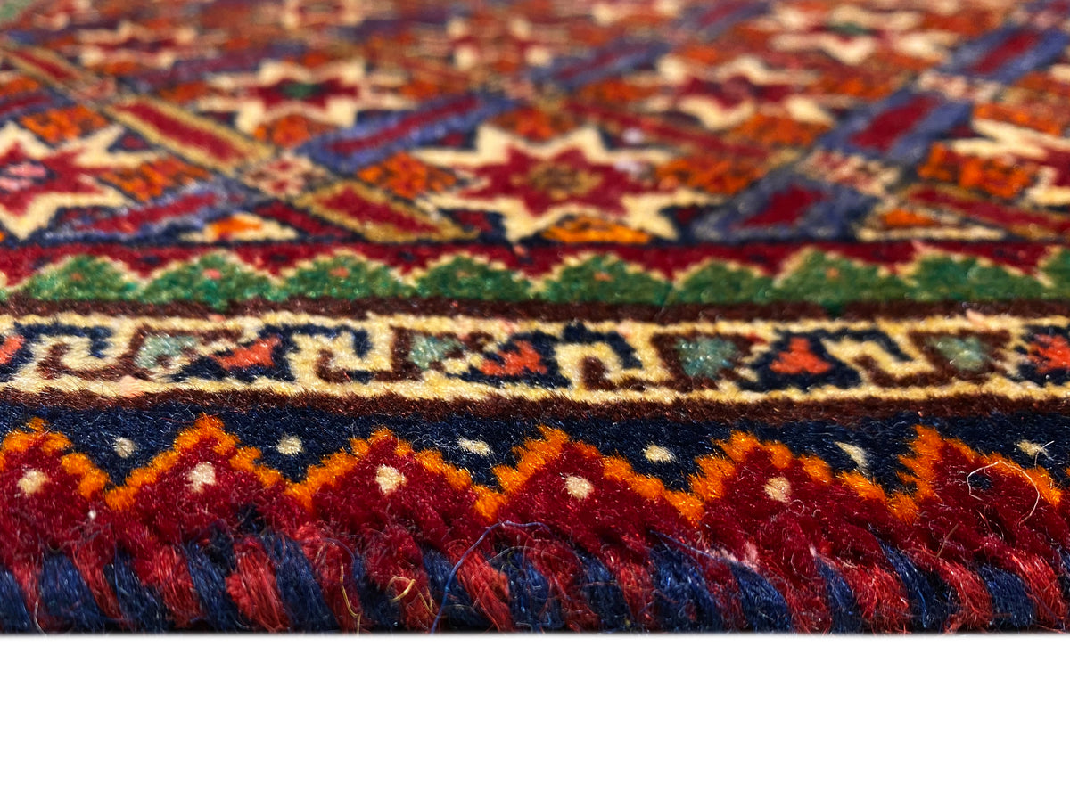 Alfombra Poshti de 62x52 cm en primer plano: franjas de colores y flecos de pelo alto.