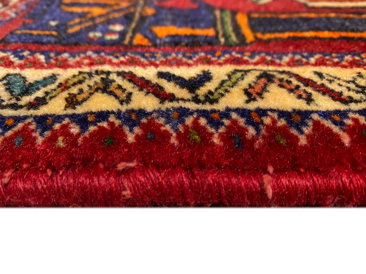 Alfombra Poshti de 66x62 cm Detalle del borde: pelo rojo denso con cenefa de colores.
