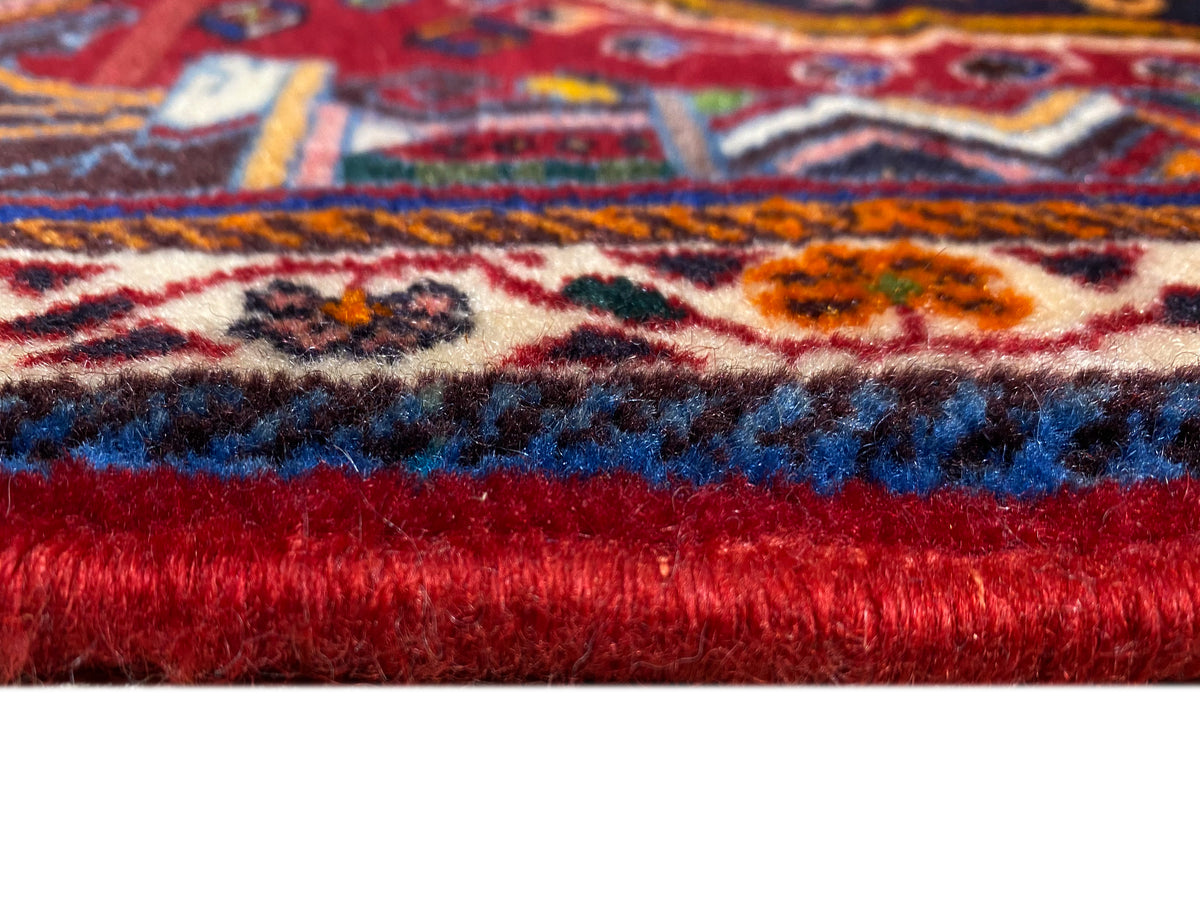 Detalle de alfombra de pelo corto y parte inferior roja, con franjas de estampado visibles
