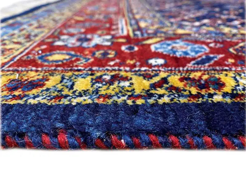 Borde de alfombra con diseño colorido y flecos en azul y rojo