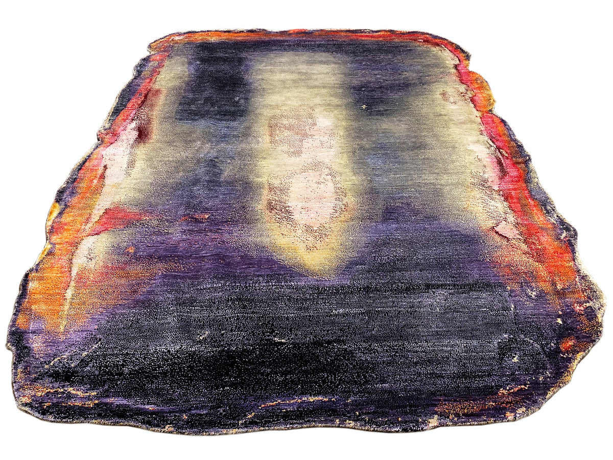 Alfombra de diseño con estampado abstracto en azul oscuro, lila, crema y naranja; borde rematado.