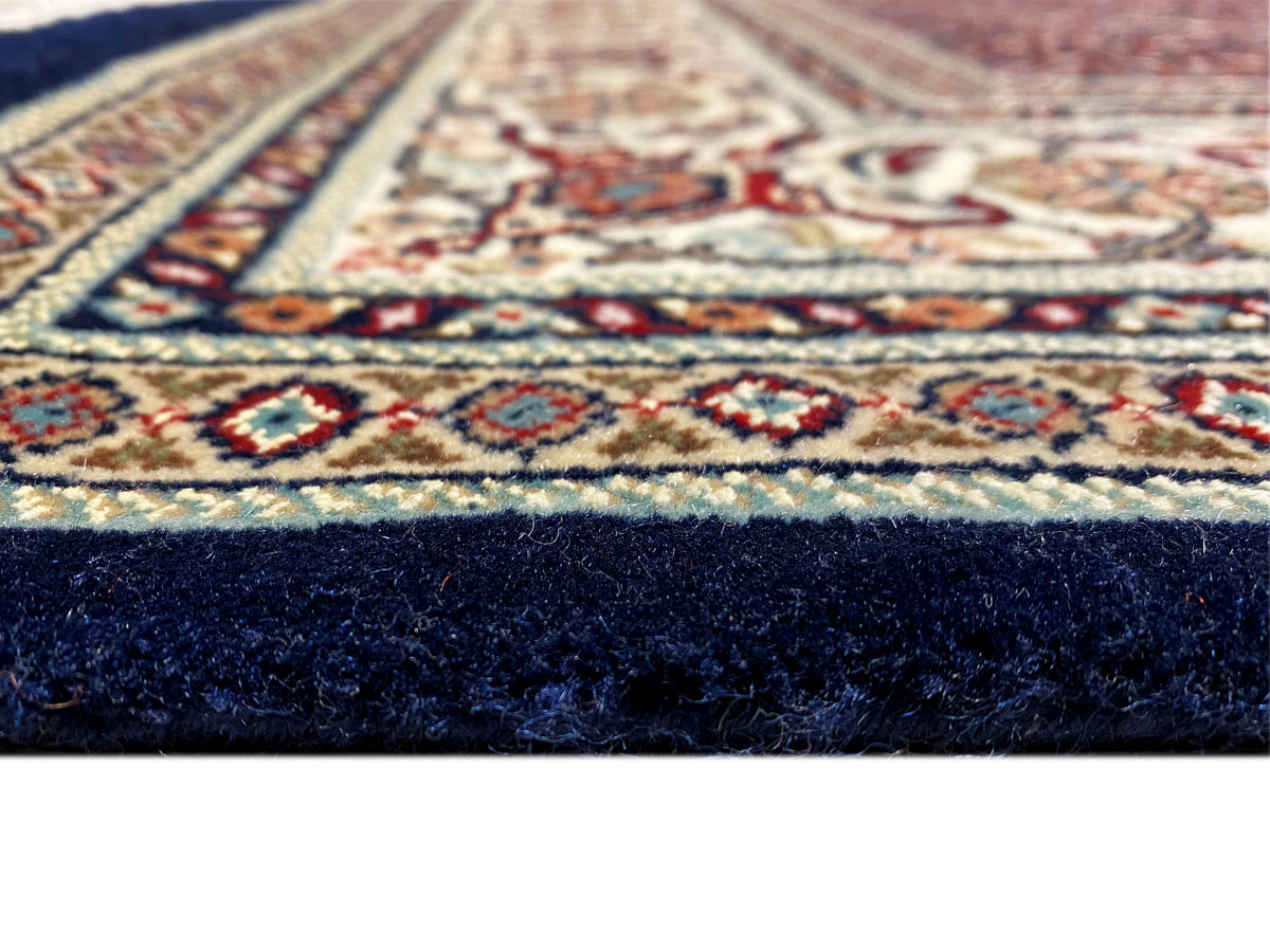 Esquina de alfombra con un delicado ornamento y pelo oscuro en el borde