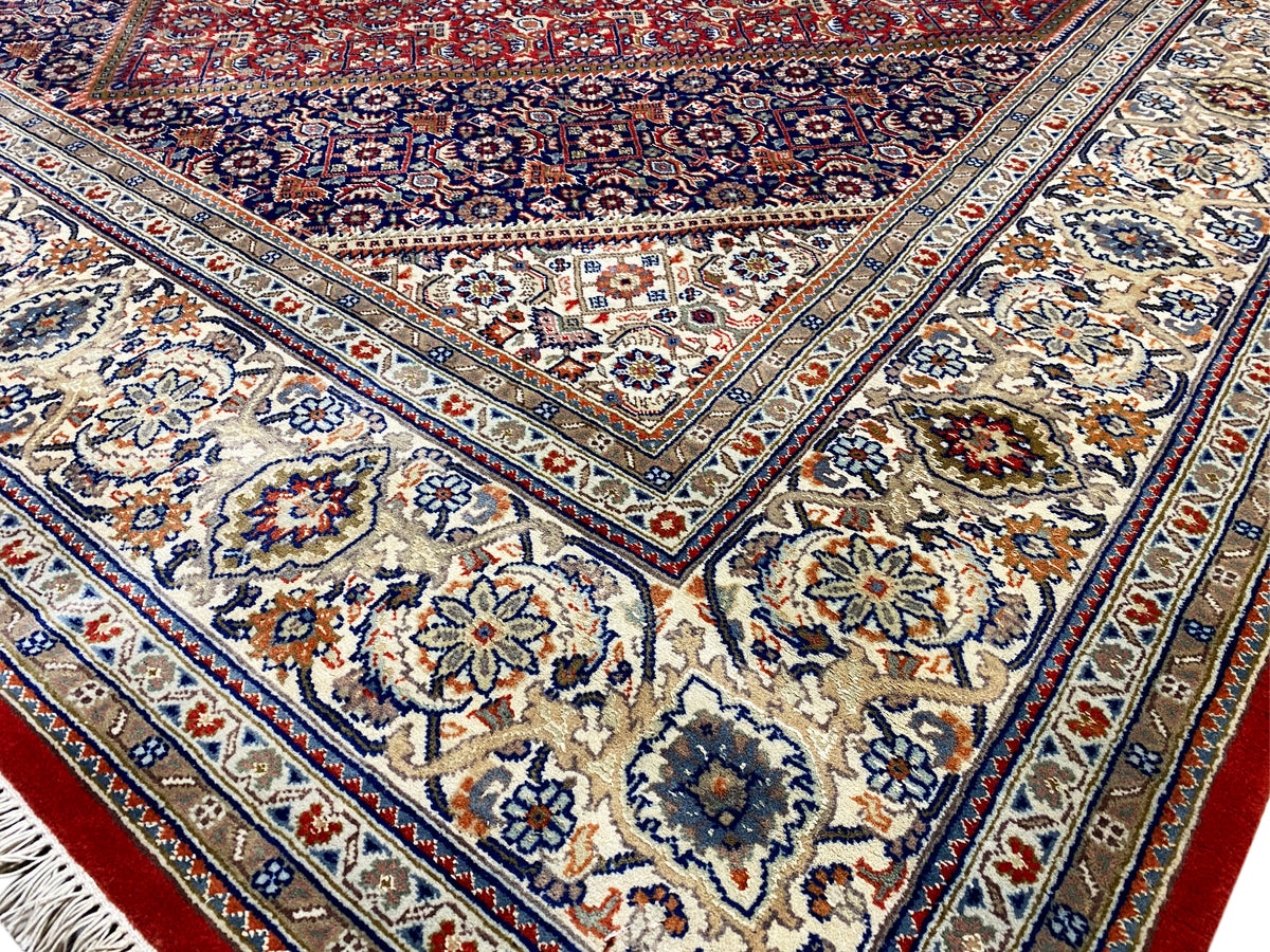 Vista detallada: centro azul con motivos florales, ornamentos circundantes y acentos rojos
