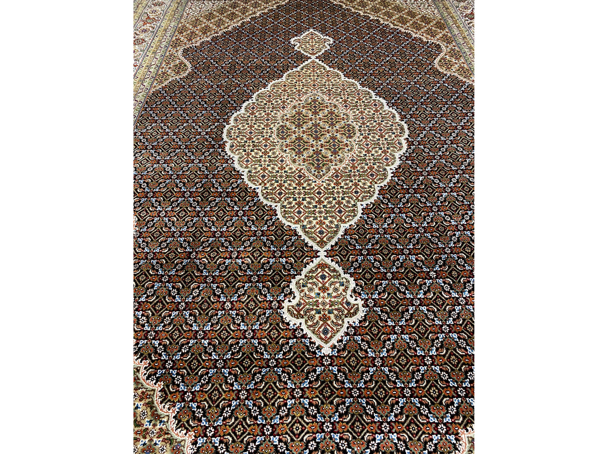 Primer plano de la alfombra Indo-Tabriz marrón: medallón central, finos rombos y ornamentos.