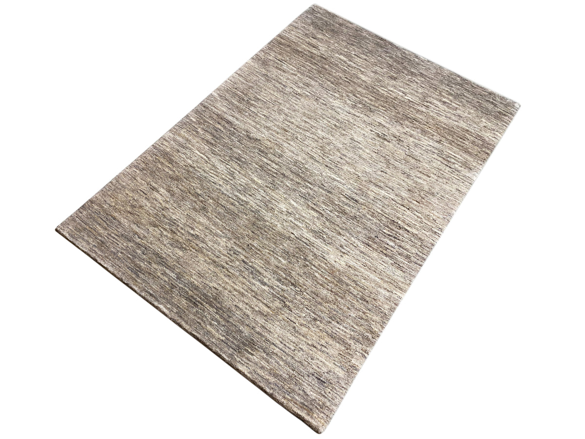 Alfombra Gabbeh rectangular, fotografiada en diagonal, acabado jaspeado gris-marrón