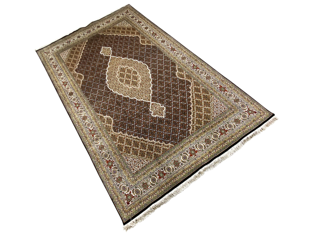 Alfombra marrón Indo-Tabriz en detalle: medallón central, cenefa fina, flecos.