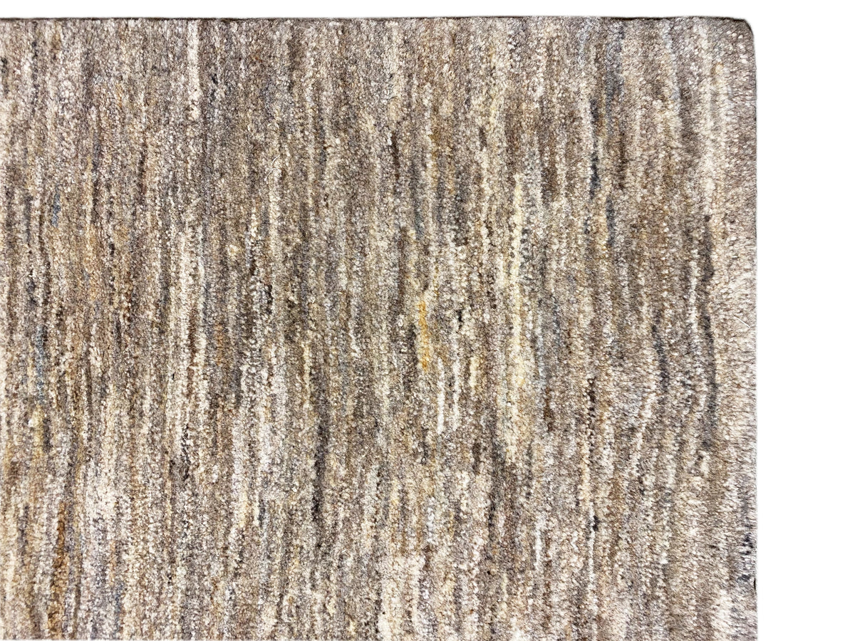 Alfombra Gabbeh, primer plano: estructura de rayas jaspeadas en beige y gris y pelo corto