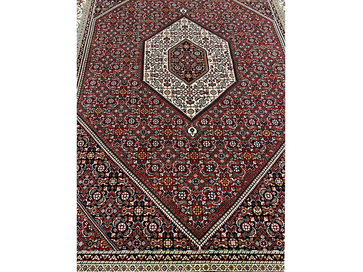 Vista de la alfombra roja con medallón central y marcos ornamentales diagonales