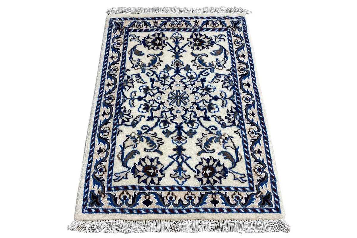 Alfombra rectangular con adornos azules y blancos y flecos en todos los lados