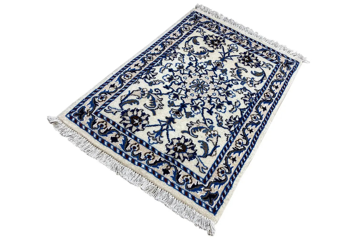 Alfombra azul y blanca con adornos de cenefa y flecos en las esquinas