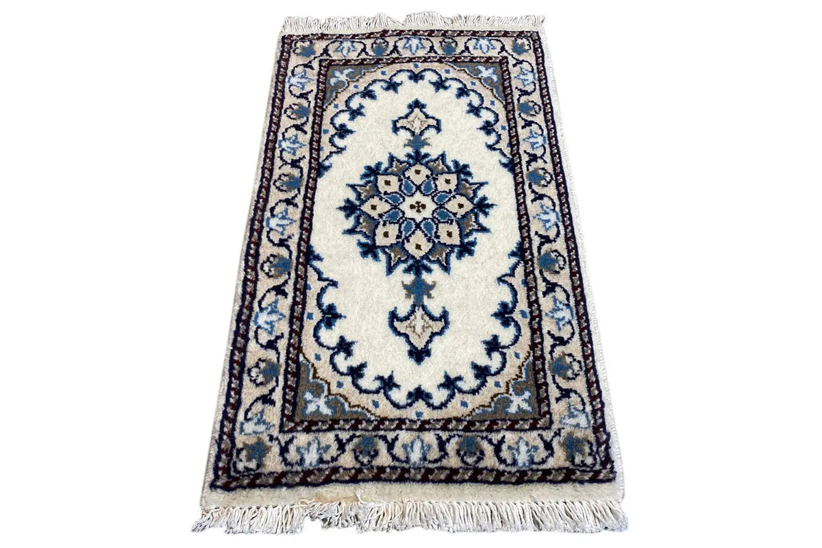 Alfombra oriental rectangular de 65x38 cm, clara, con un diseño decorativo azul y flecos en el borde