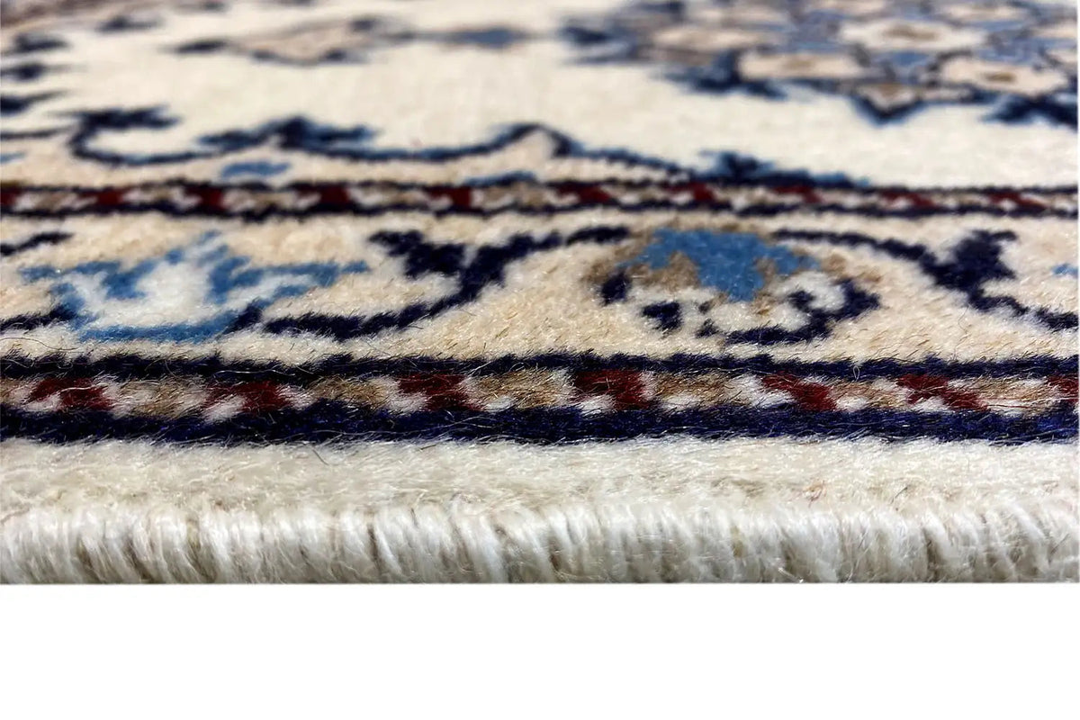 Borde de alfombra con flecos blancos y un diseño de cenefa azul, primer plano