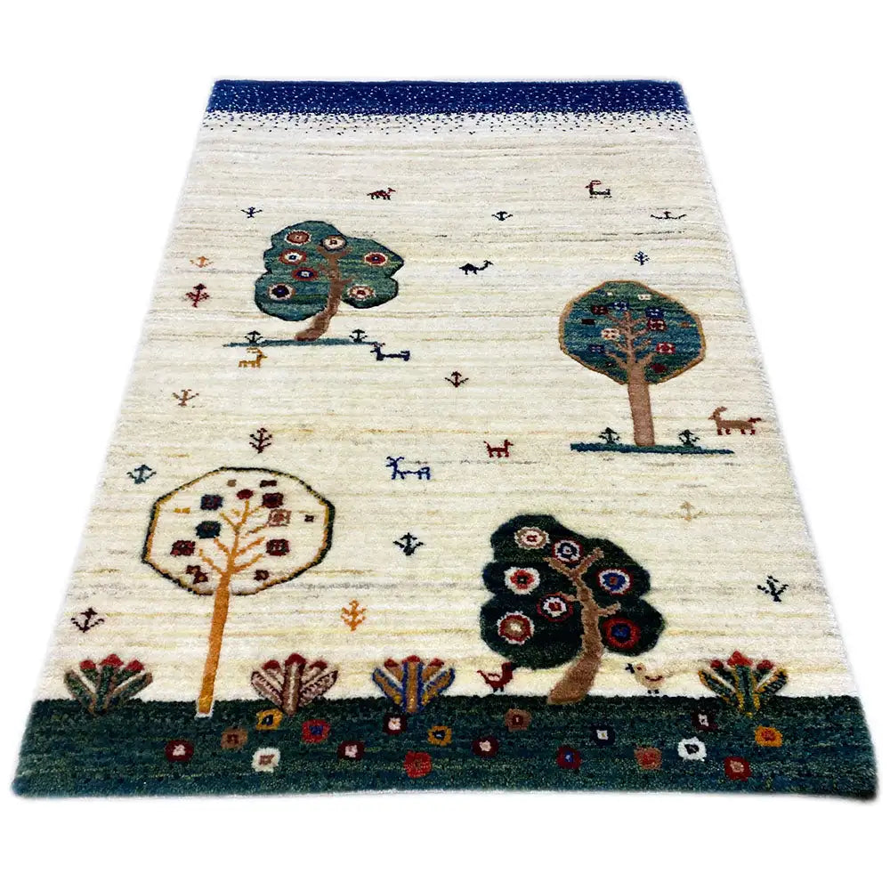 Alfombra Gabbeh, de color crema con borde azul y motivos de árboles y animales en el diseño