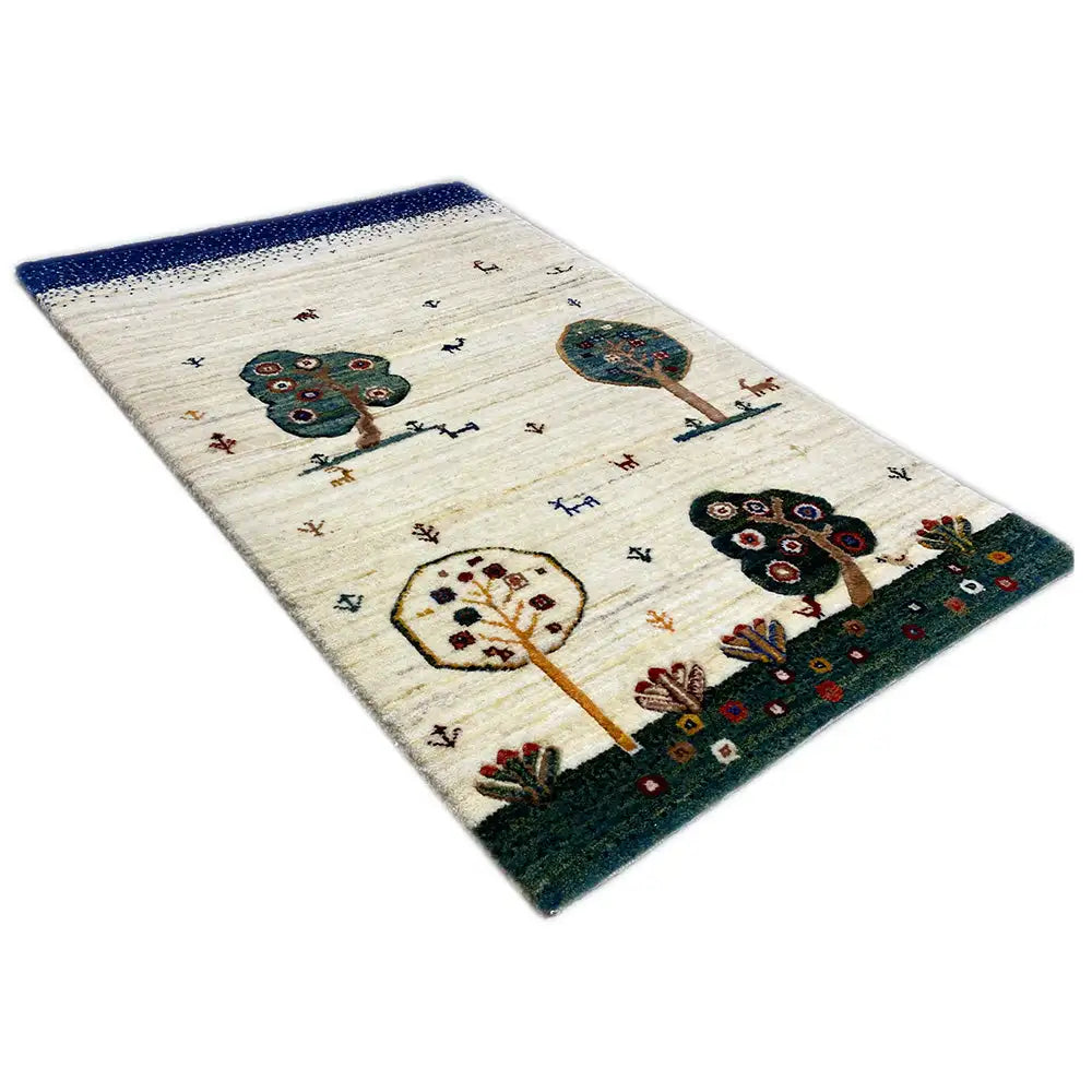 Alfombra Gabbeh con borde azul, color de fondo crema y motivos coloridos de árboles y animales