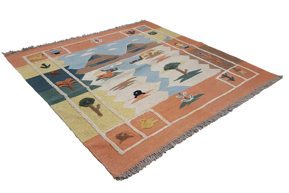 Alfombra kilim extendida; campo central azul con animales y árboles, borde naranja, flecos