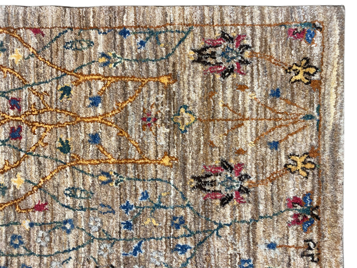 Teppich-Detail: beiger Flor mit blauen Ornamenten, roten Blüten und goldenen Linien