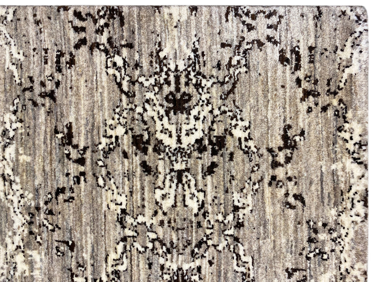 Primer plano: alfombra de color beige claro con manchas negras y grises, textura vertical
