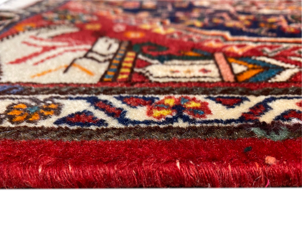Teppich im Nahaufnahmen-Anschnitt mit rot-rotem Flor und mehrfarbigem Randmuster