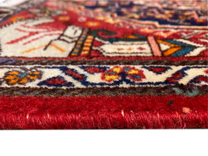 Teppich im Nahaufnahmen-Anschnitt mit rot-rotem Flor und mehrfarbigem Randmuster