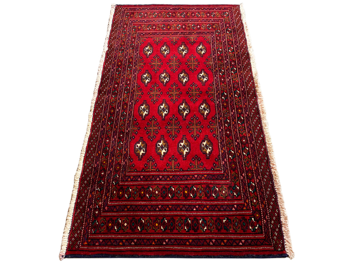 Turkmen Teppich, rot-schwarzer Rand, zentrale Medaillons und seitliche Fransen, schräg gelegt