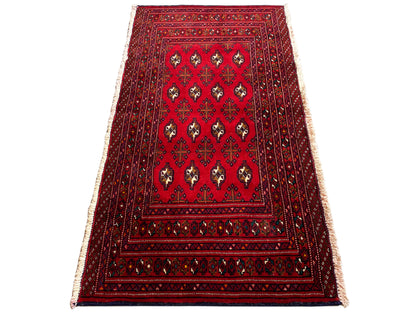 Turkmen Teppich, rot-schwarzer Rand, zentrale Medaillons und seitliche Fransen, schräg gelegt