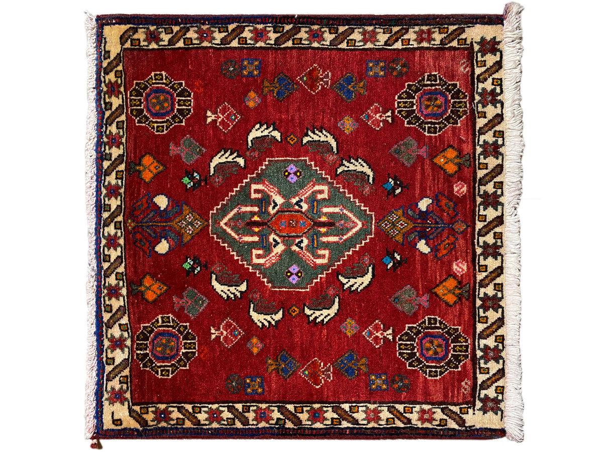 Alfombra Poshti de 58x57 cm, con motivo ornamental vintage rojo, cenefa en el borde y flecos