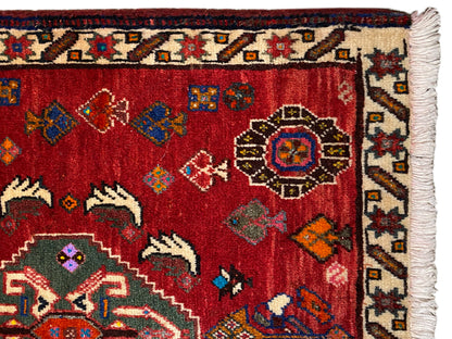Vista cercana de alfombra Poshti de 58x57 cm: pelo rojo con ornamentos y borde con flecos