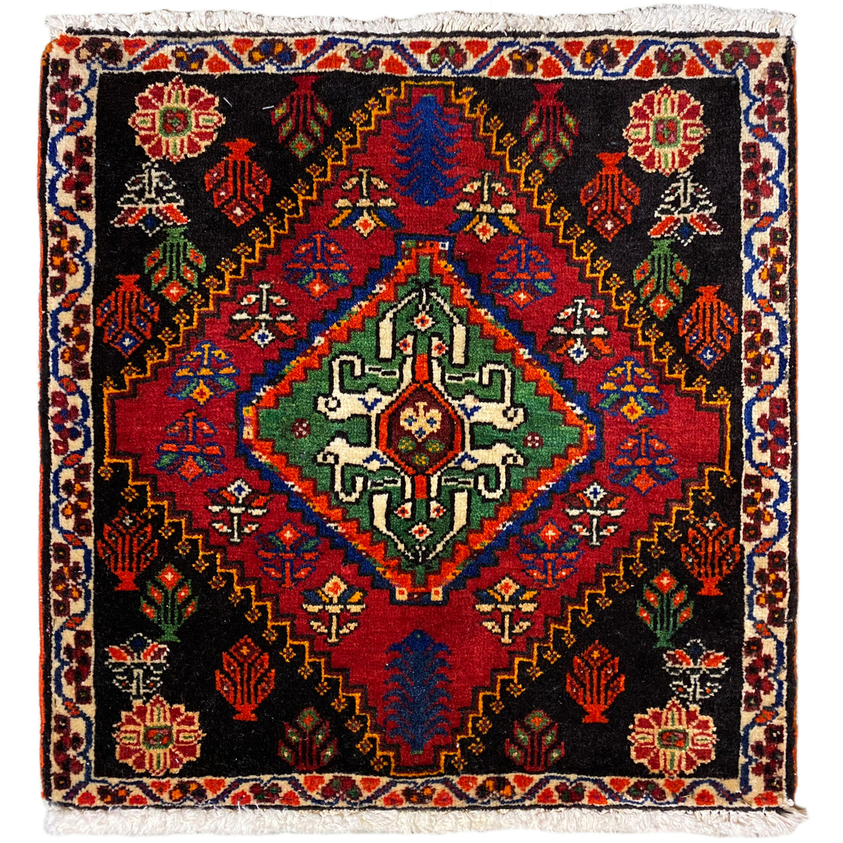 Alfombra Poshti de 56x56 cm con fondo negro, adornos de colores y flecos decorativos