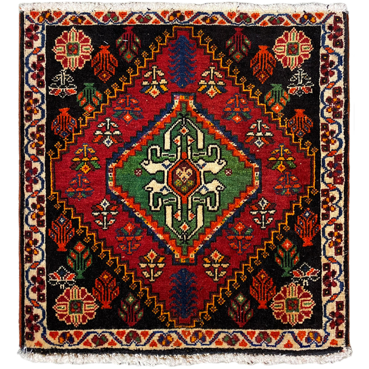 Alfombra Poshti, cuadrada: alfombra tejida negra con un motivo decorativo rojo, verde y azul