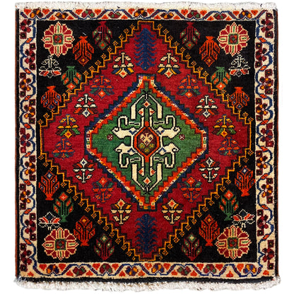 Alfombra Poshti, cuadrada: alfombra tejida negra con un motivo decorativo rojo, verde y azul