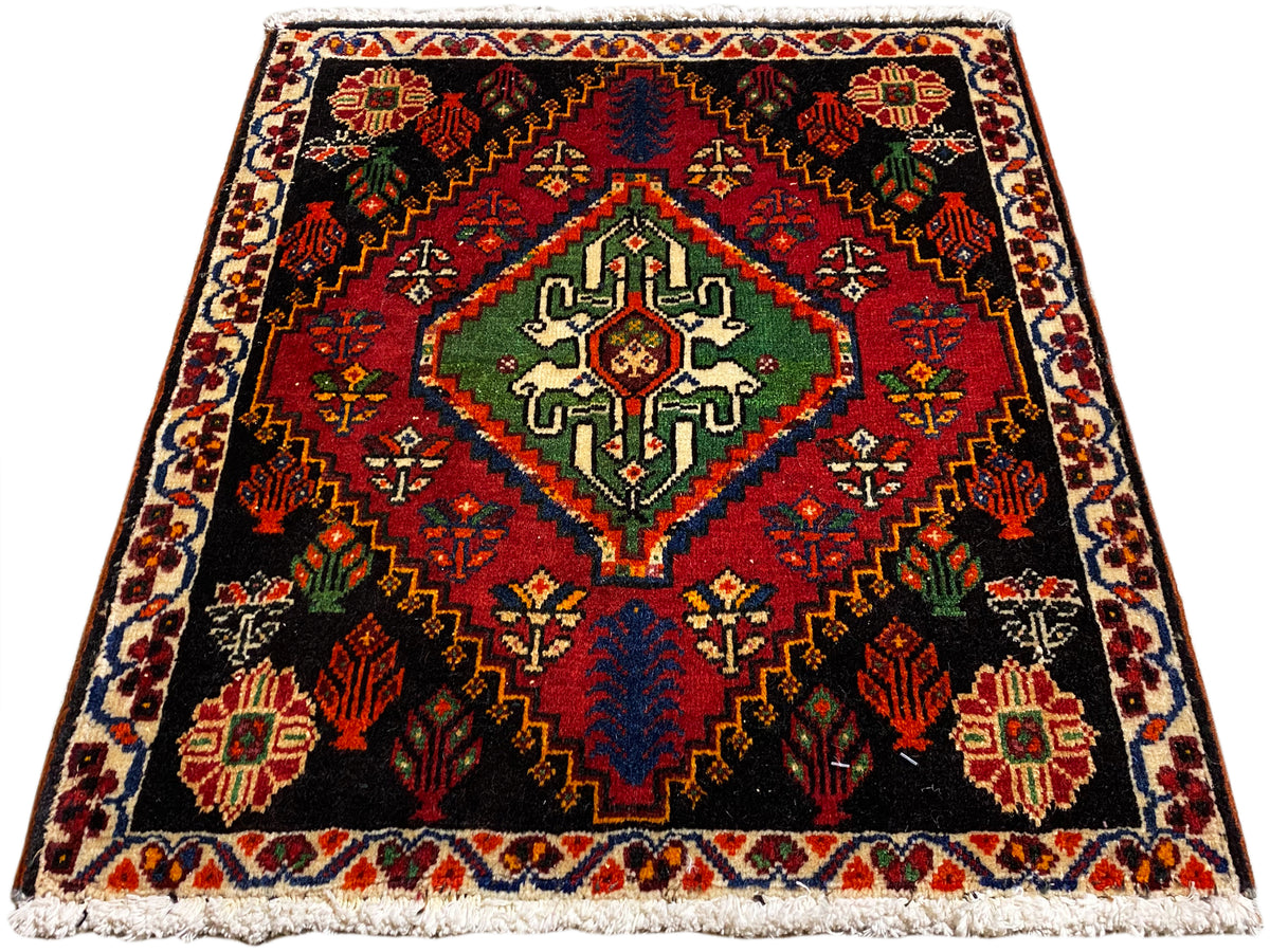 Alfombra cuadrada Poshti, fondo negro con un diseño central en verde, rojo y azul
