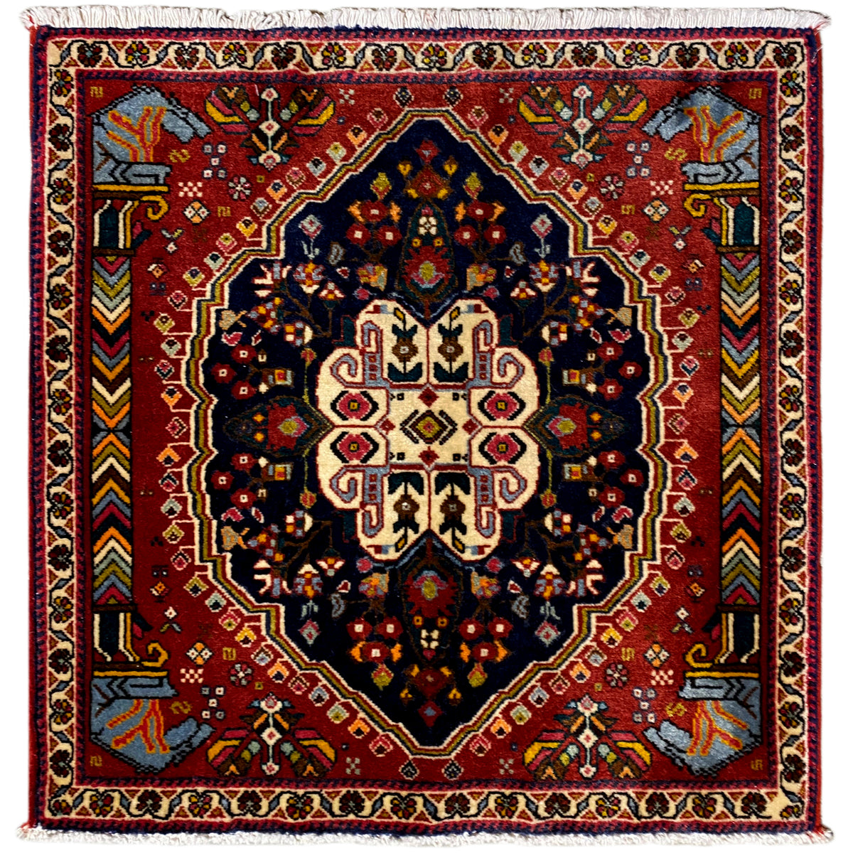 Alfombra Poshti con fondo rojo, patrón de octágonos azul oscuro y borde de cenefa blanco