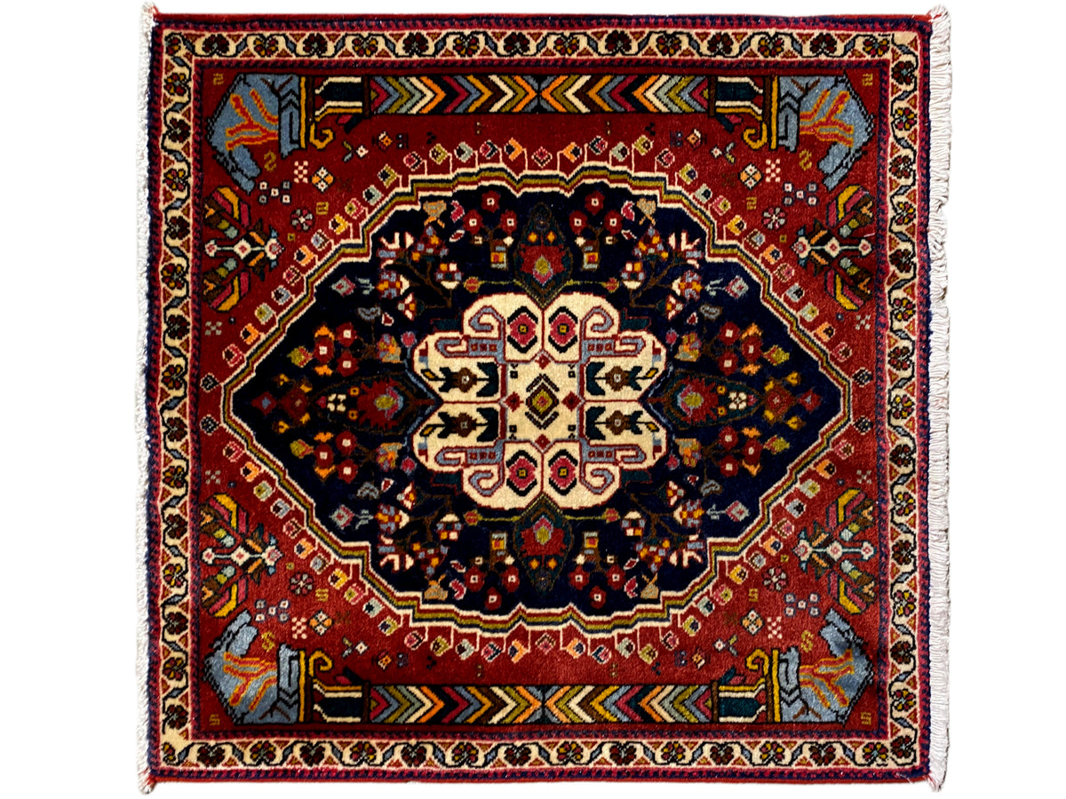 Alfombra Poshti con fondo rojo, medallón oscuro y ornamentos de marco multicolores