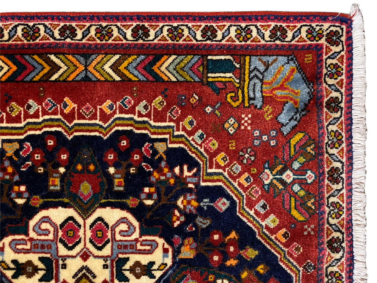 Detalle de la cenefa de la alfombra Poshti con ornamentos rojos, azules y amarillos