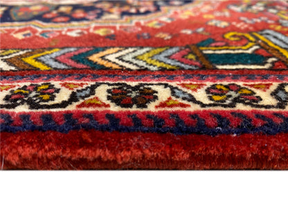 Detalle del borde de la alfombra Poshti con flecos rojos y azules y diseños tejidos