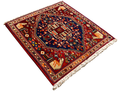Alfombra Poshti de 64x64 cm, cuadrada, diagonal, con un motivo de cenefa rojo y centro azul oscuro