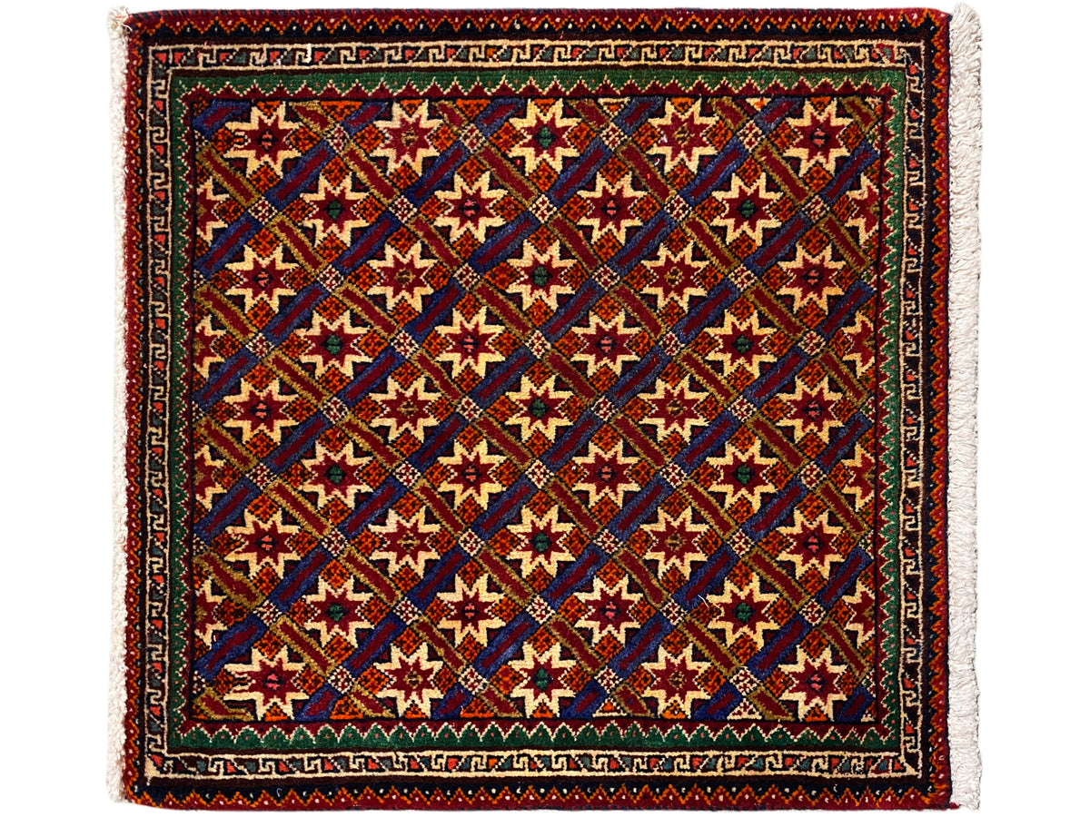 Alfombra Poshti de 62x52 cm, con fondo oscuro, estrellas de colores y flecos.
