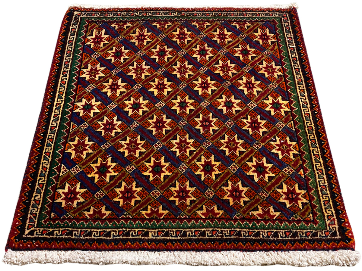Alfombra Poshti de 62x52 cm, vista diagonal: patrones rojos, azules y verdes con flecos.