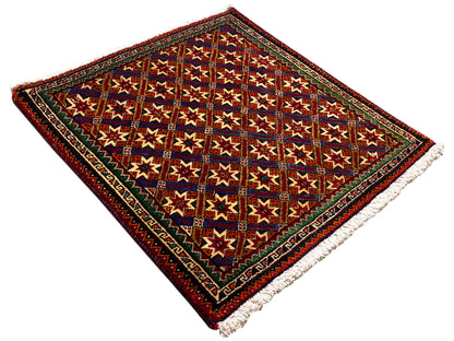 Alfombra Poshti de 62x52 cm, pantalla plana: estrellas de colores en un marco rojo oscuro, flecos.