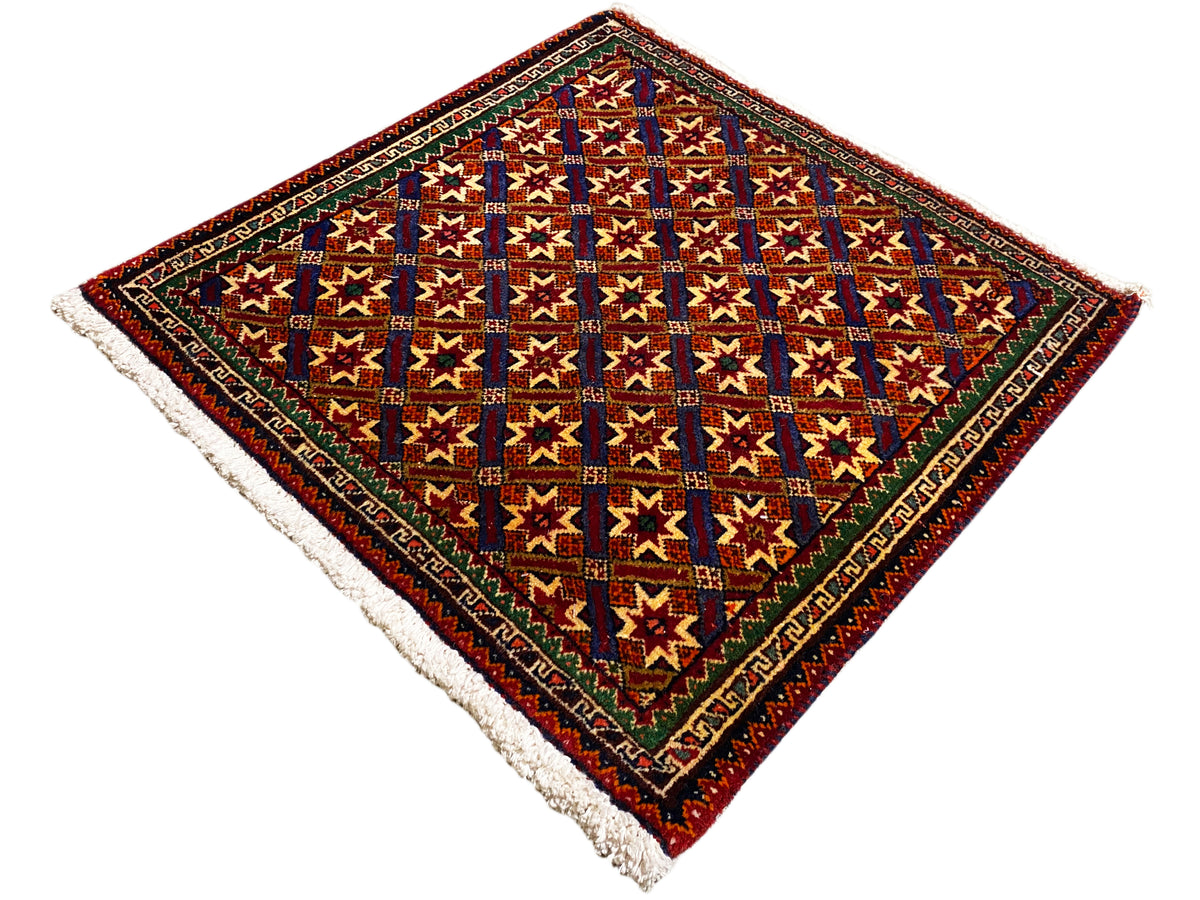 Alfombra Poshti de 62x52 cm, vista detallada: cuadrados y estrellas de colores, borde oscuro, flecos.