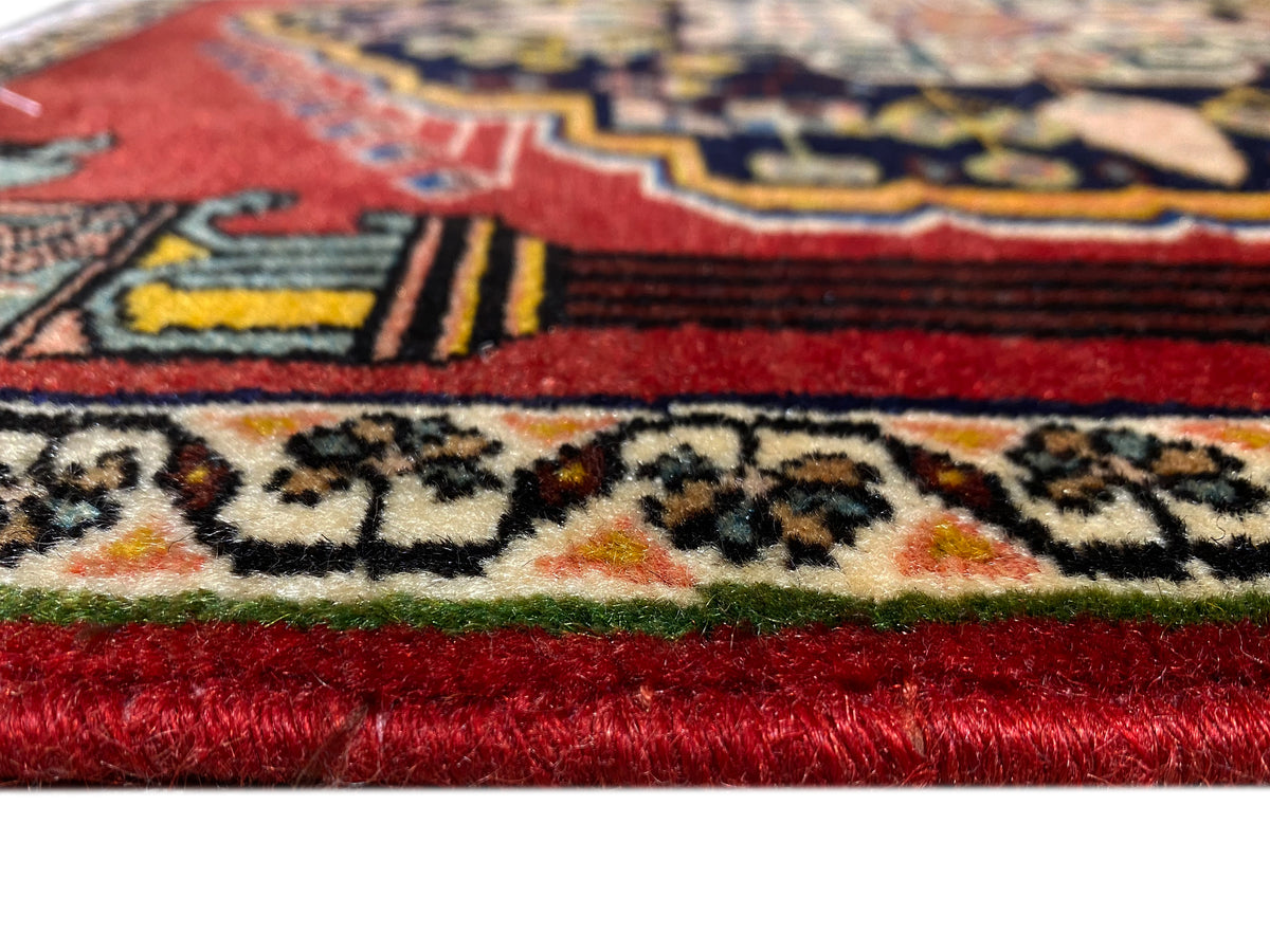 Alfombra Poshti con pelo rojo y adornos multicolores en el borde