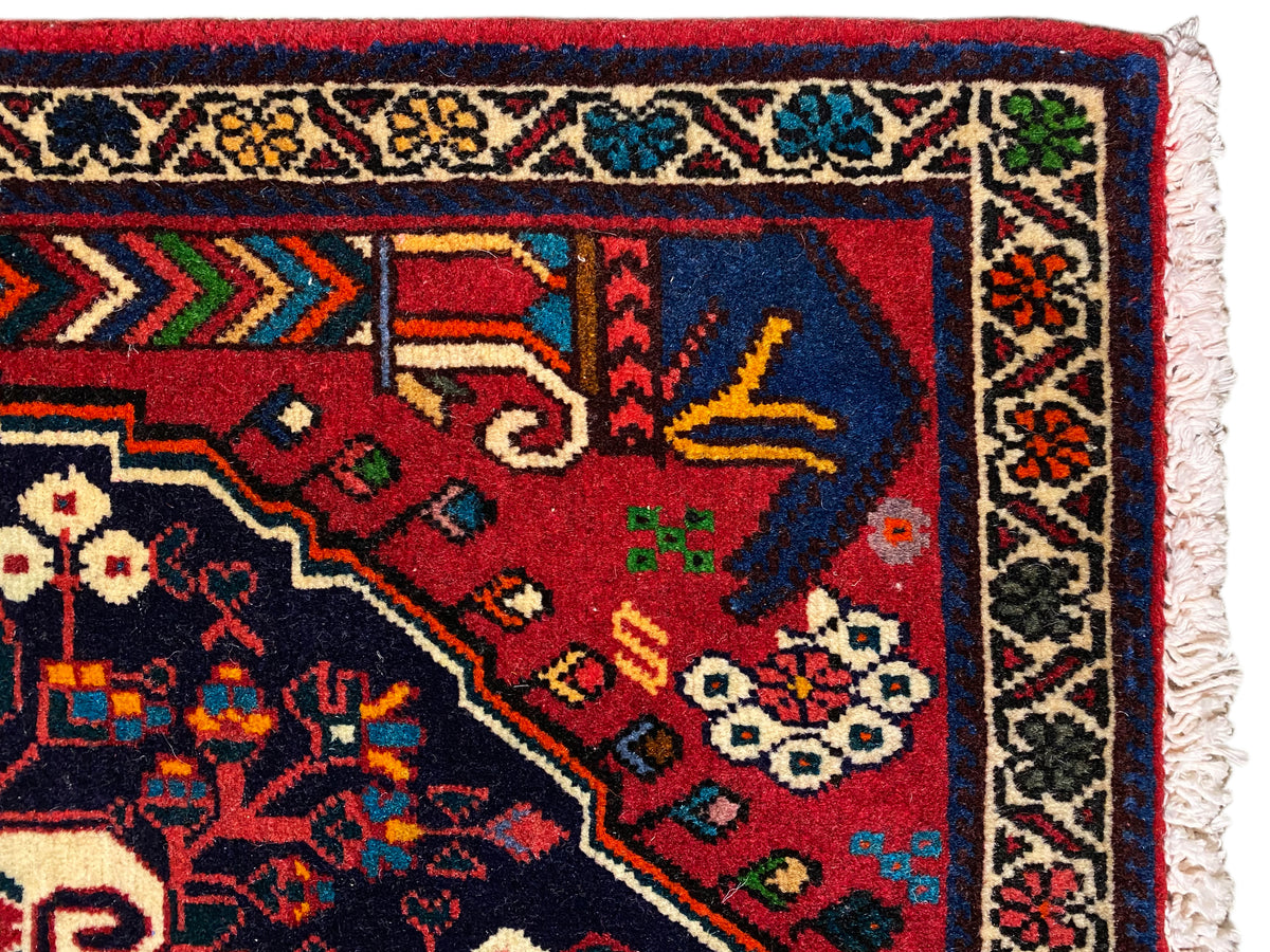 Esquina de alfombra con cenefa estampada multicolor en rojo, azul, verde y beige