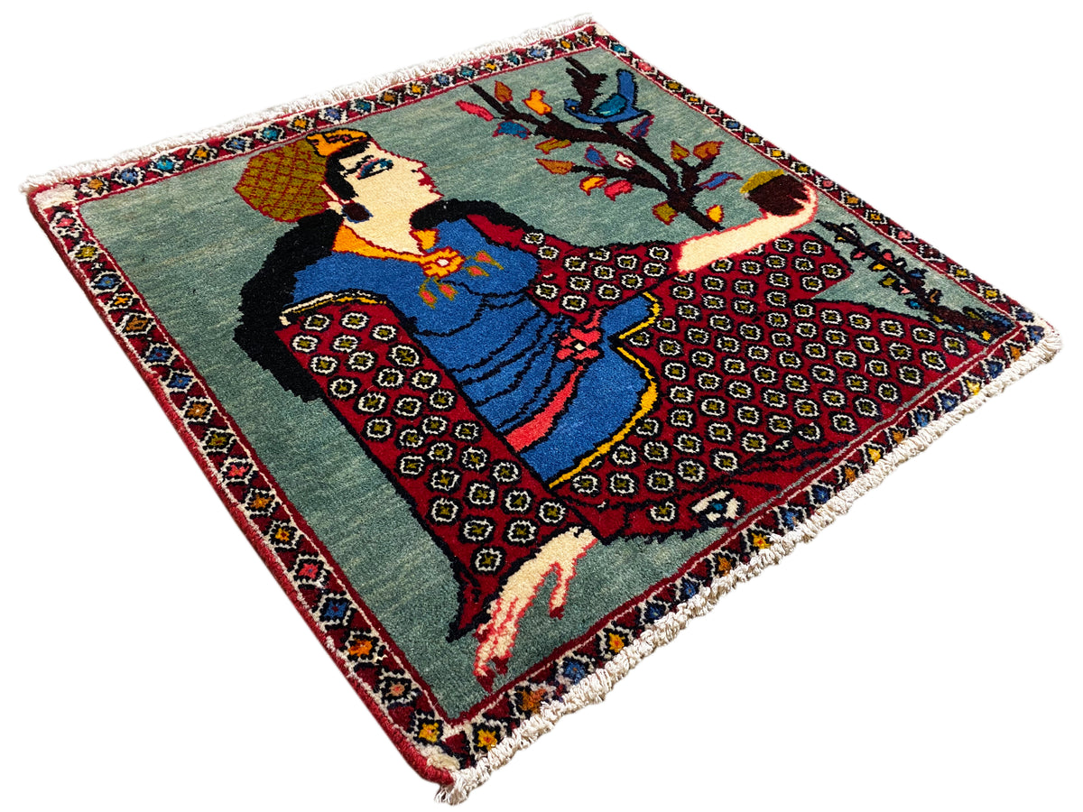Alfombra Poshti de 68x63 cm en diagonal desde arriba: motivo de figura con árbol, borde de colores, flecos