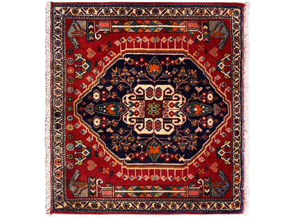 Alfombra con fondo rojo, medallón azul oscuro y cenefa multicolor, cuadrada