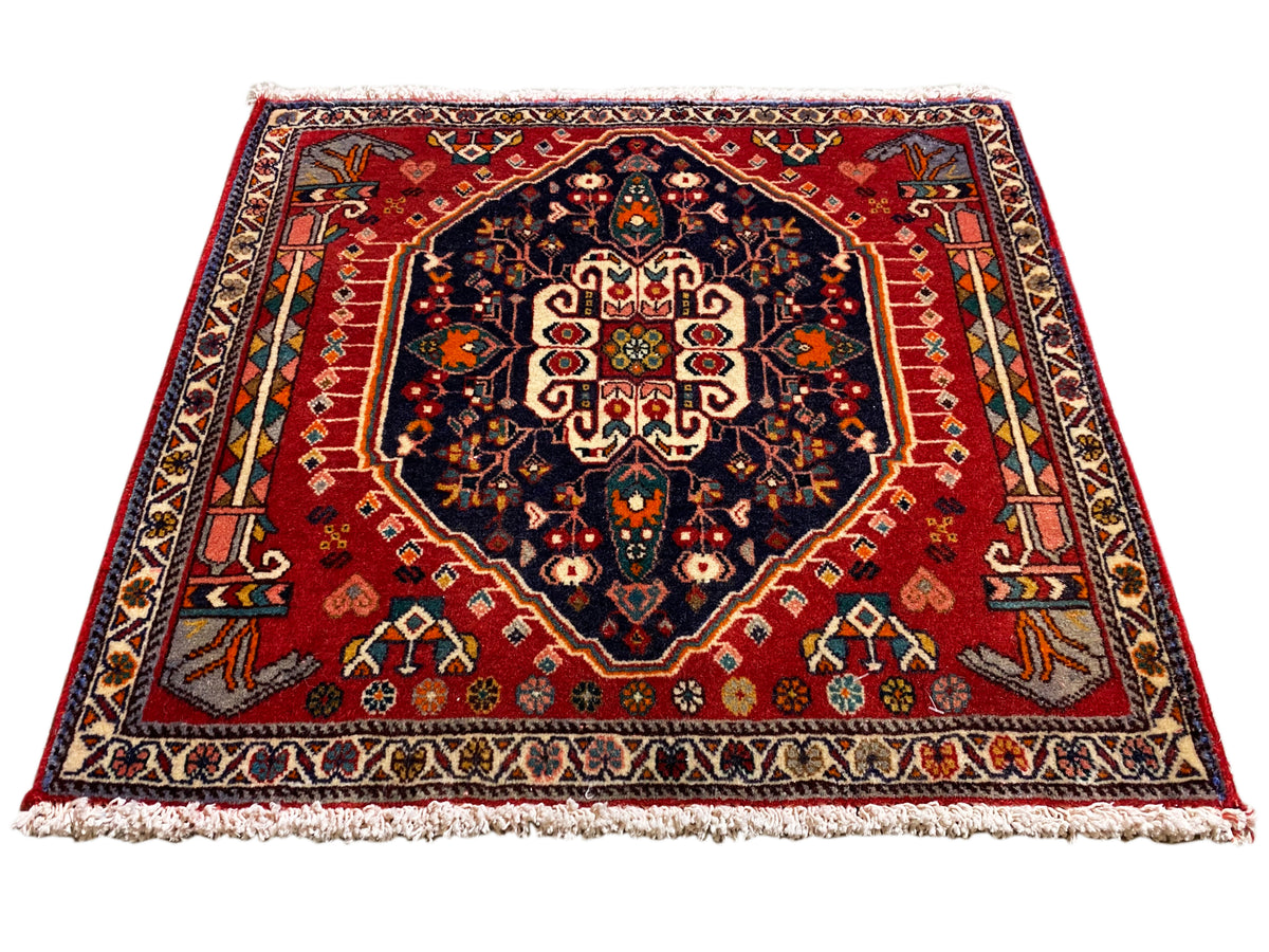 Alfombra con fondo rojo, medallón azul oscuro, ornamento simétrico, rectangular