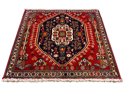 Alfombra con fondo rojo, medallón azul oscuro, ornamento simétrico, rectangular