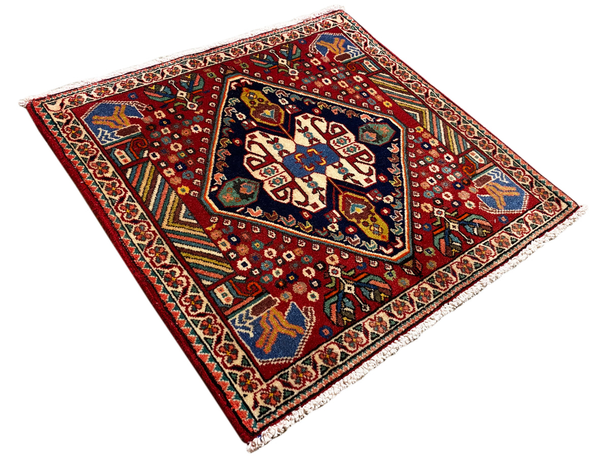 Alfombra de 66x62 cm: vista diagonal del medallón con cenefa decorativa y flecos
