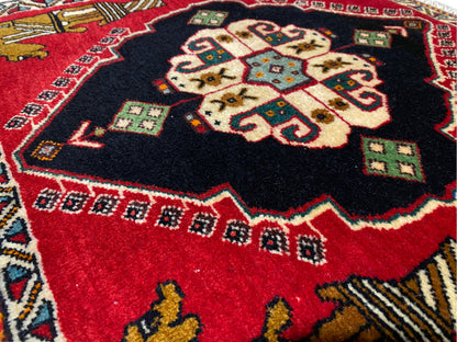 Alfombra Poshti de 63x55 cm: primer plano del medallón central con un diseño rojo y negro